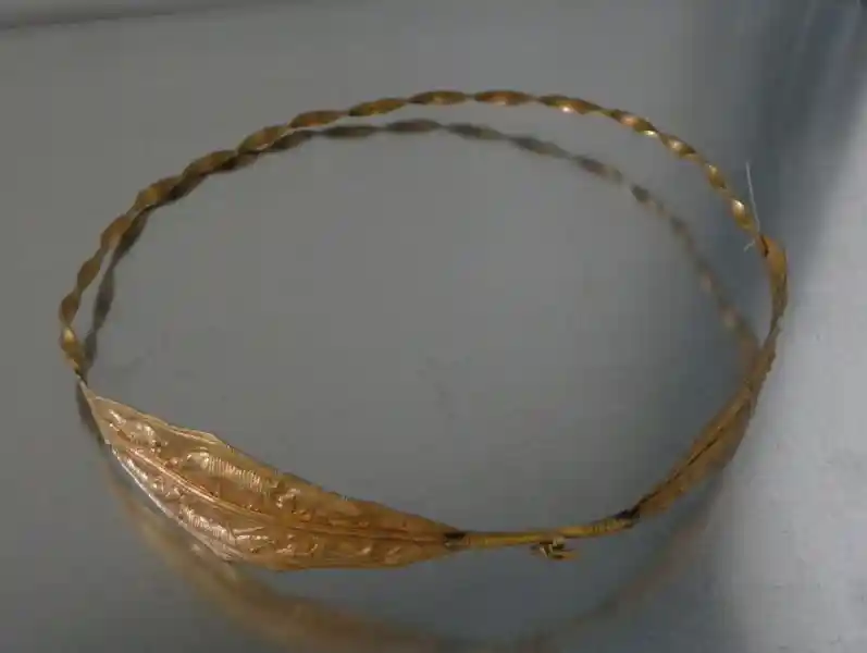A gold bracelet with an animal design. A gold bracelet with an animal design.